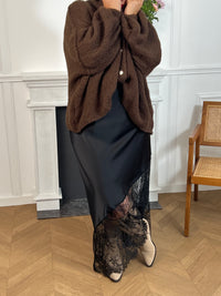 Gilet noir en maille épaisse, chaleureux et élégant. Ses boutons argentés apportent une touche raffinée à ce basique intemporel, facile à porter au quotidien.