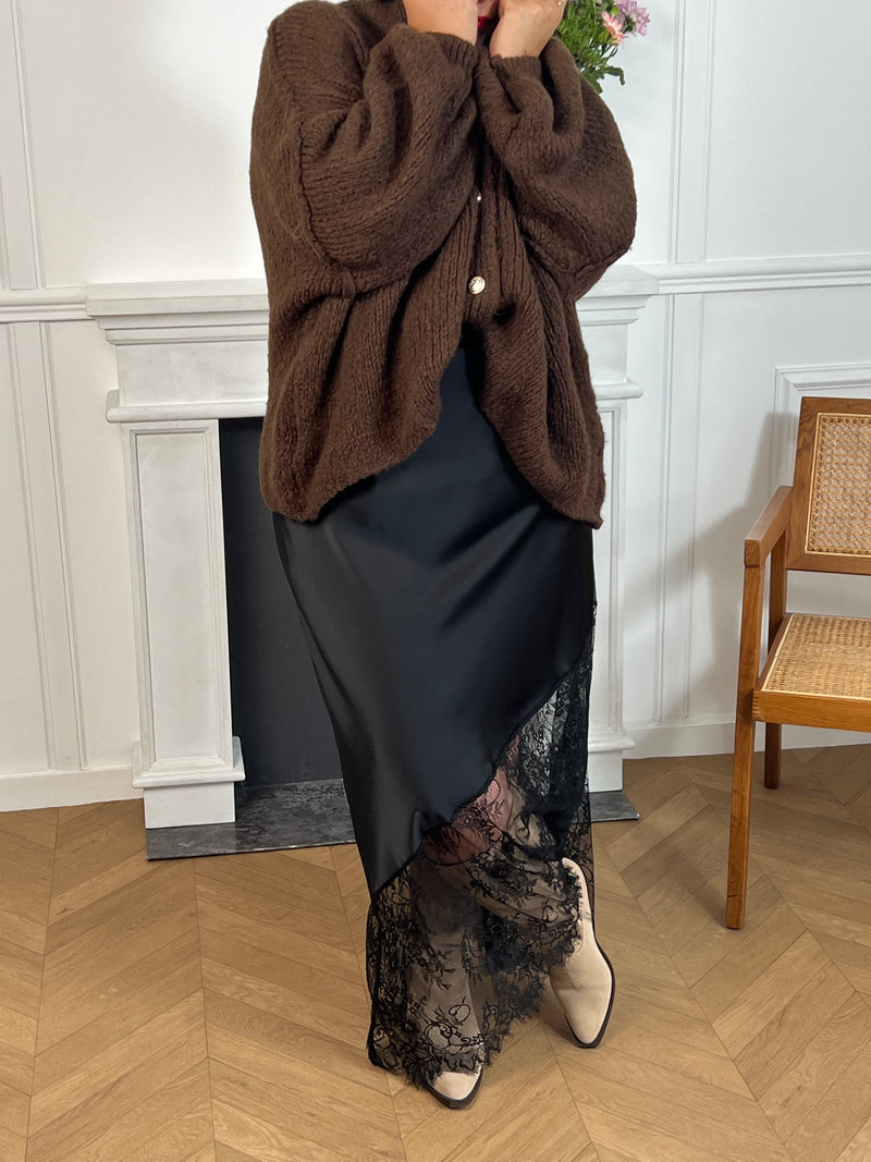 Gilet noir en maille épaisse, chaleureux et élégant. Ses boutons argentés apportent une touche raffinée à ce basique intemporel, facile à porter au quotidien.
