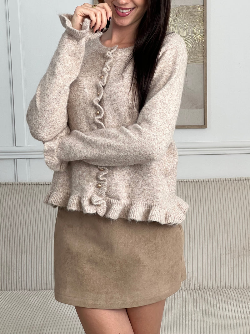 Ce gilet beige allie élégance et originalité grâce à ses jolis volants au niveau des boutons, du bas et des poignets. Ses boutons dorés sur toute la longueur apportent une touche lumineuse et sophistiquée, pour un style à la fois doux et chic.