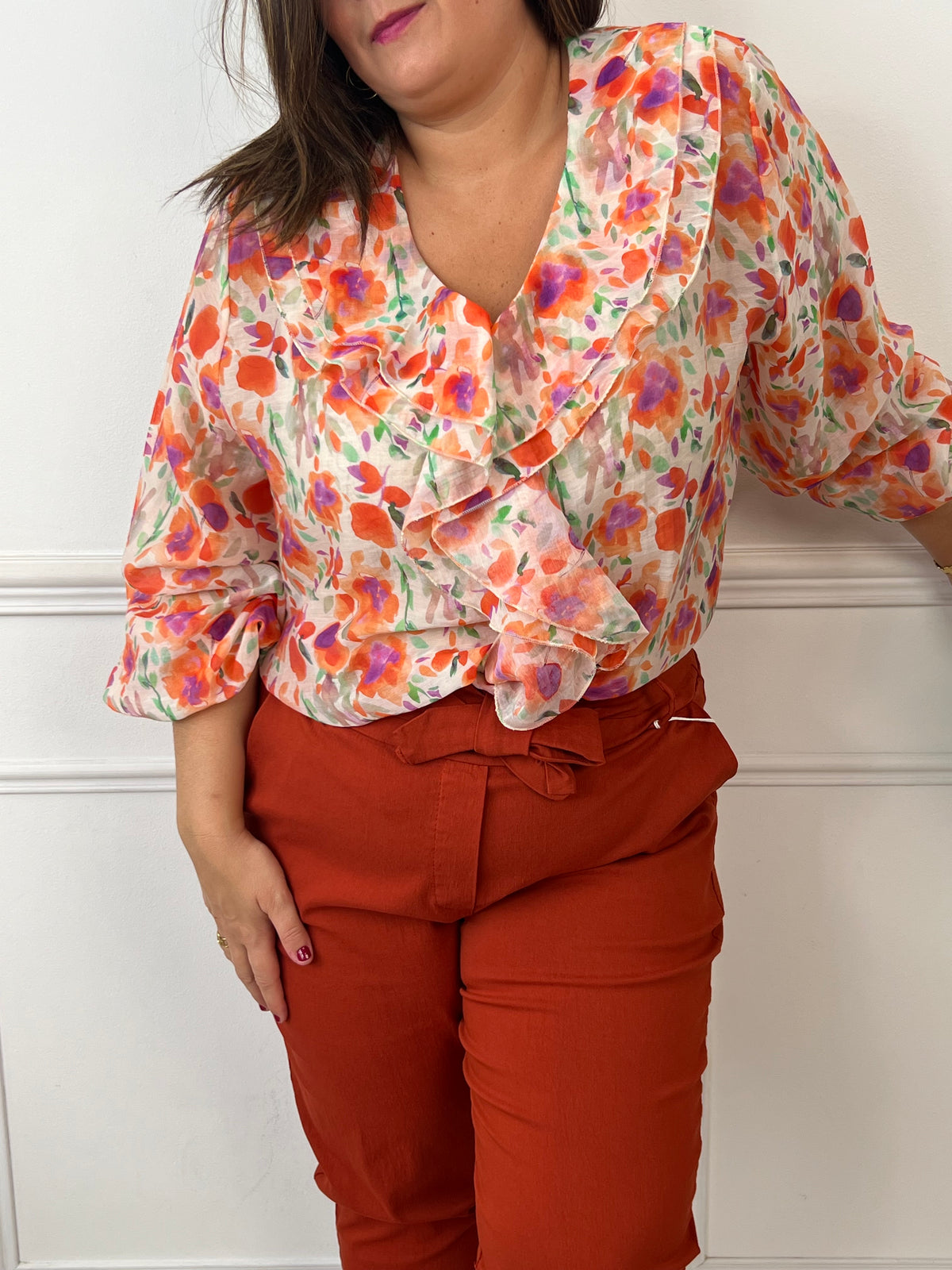 Faites éclore votre style avec notre blouse fleurie orange "Astrid"! Avec ses manches longues, col V volanté et poignets élastiques, cette blouse fluide offre une féminité et une élégance.