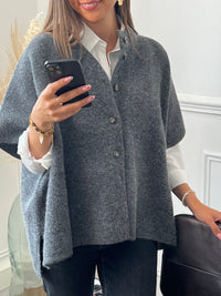 Un gilet effet poncho gris, offrant une silhouette fluide et décontractée. Sa coupe ample et ses lignes minimalistes en font une pièce facile à porter, idéale pour superposer et ajouter une touche de style décontracté à vos tenues.