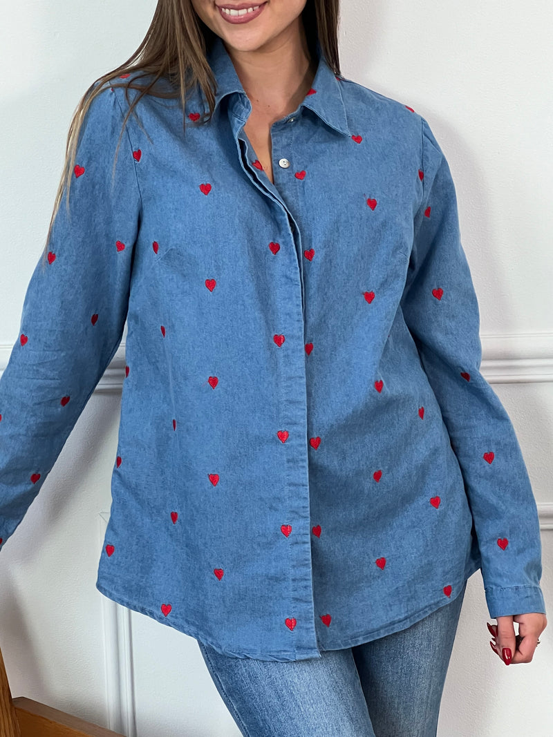 Ajoutez une touche d'amour à votre garde-robe avec notre chemise bleue Alix, ornée de petits coeurs rouges. Les manches longues peuvent être retroussées pour un style décontracté, tandis que le col chemise et les boutons sur le devant apportent une touche classique.&nbsp;