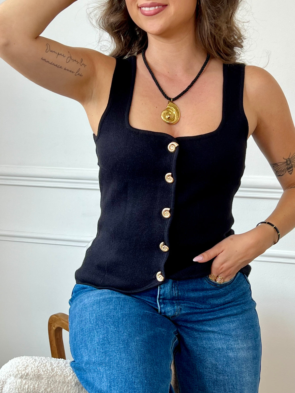 Gilet sans manches au charme vintage, doté d’un col carré structuré et rehaussé de boutons dorés en forme de coquillage. Une pièce délicate et originale, parfaite pour apporter une touche de caractère à vos tenues.