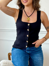Gilet sans manches au charme vintage, doté d’un col carré structuré et rehaussé de boutons dorés en forme de coquillage. Une pièce délicate et originale, parfaite pour apporter une touche de caractère à vos tenues.