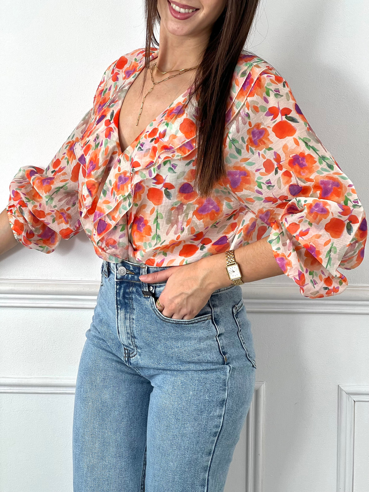Faites éclore votre style avec notre blouse fleurie orange "Astrid"! Avec ses manches longues, col V volanté et poignets élastiques, cette blouse fluide offre une féminité et une élégance.