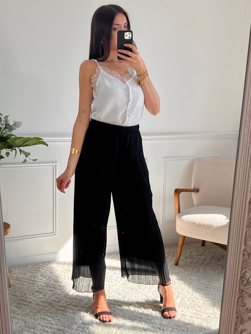 Léger et élégant, ce pantalon plissé noir séduit par sa coupe fluide et sa teinte chaude. Parfait pour une silhouette allongée et un style tout en douceur.