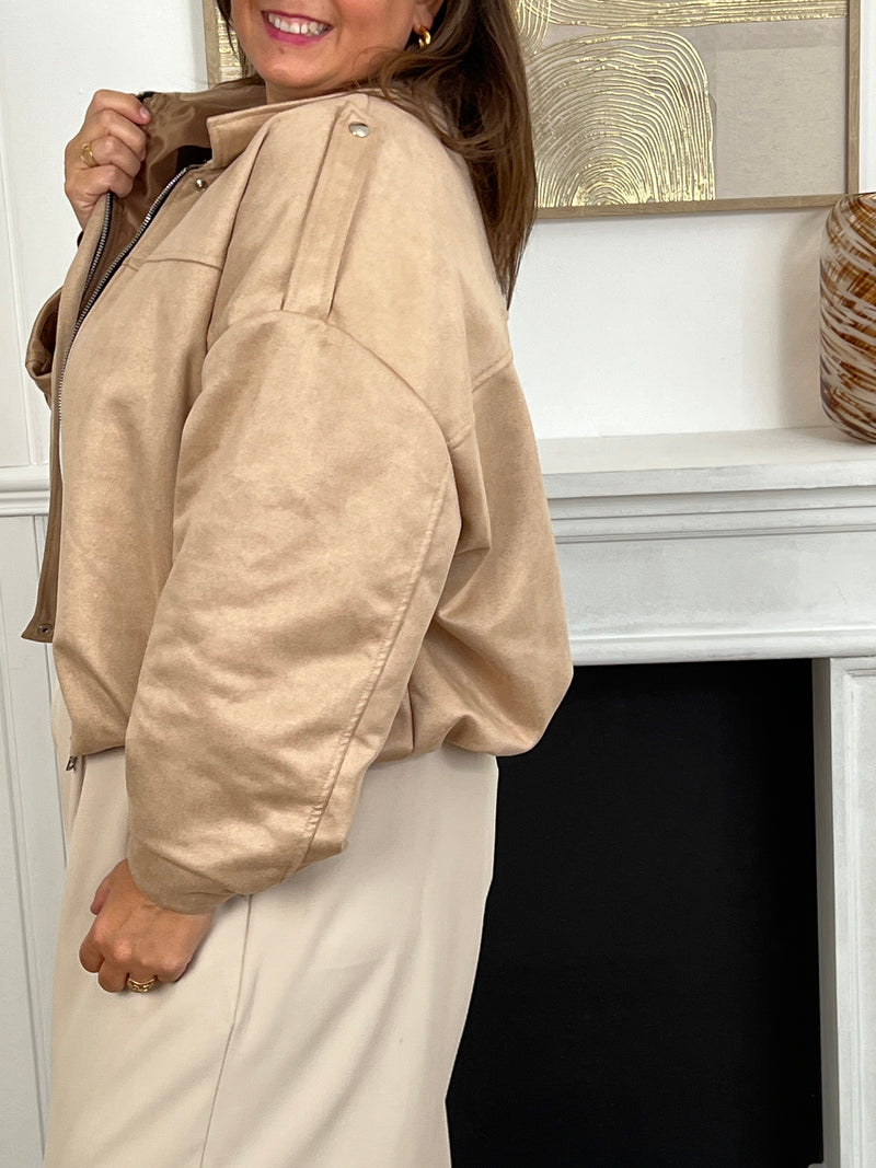 Cette veste courte style bombers se décline dans une teinte beige et tendance. Avec sa coupe moderne et son esprit casual-chic, elle apporte une touche de caractère à toutes vos tenues. Légère et polyvalente, elle se porte aussi bien au quotidien que pour compléter un look plus travaillé.