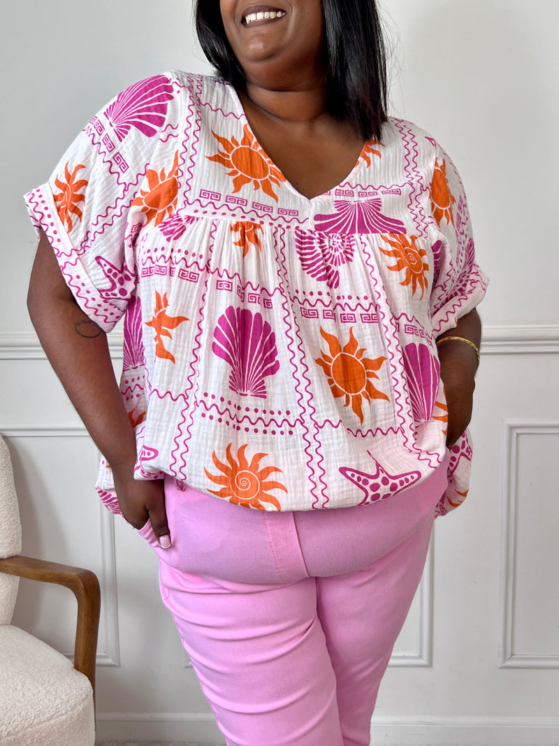 Blouse grande taille en gaze de coton ajourée, col V et manches courtes. Motifs coquillage et soleil en écru, orange et violet pour un look audacieux et frais.