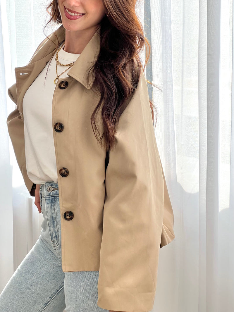 Découvrez notre trench court Eda, la pièce incontournable pour sublimer vos tenues. Confectionné en beige intemporel, ce manteau allie élégance et polyvalence.