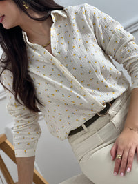 Chemise beige en gaze de coton, parfaite pour les silhouettes généreuses. Manches longues retroussables avec boutons discrets pour adapter votre style au fil de la journée. Col chemise structuré et boutons sur toute la longueur pour un look intemporel. Motifs floraux jaune et vert qui apportent une touche de gaieté à votre garde-robe.