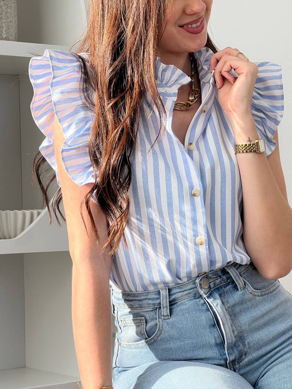 Adoptez cette chemise bleue et écrue femme sans manches, légère et élégante. Elle se ferme par des boutons sur toute la longueur et se distingue par ses volants au col et aux épaules, apportant une touche féminine. Ses rayures verticales en bleu et écru allongent la silhouette et subliment vos tenues.