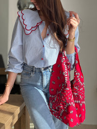 Chemise femme bleue à rayures avec col claudine, parfaite pour un look élégant et féminin. Ses manches longues et ses boutons rouges sur toute la longueur apportent une touche originale et raffinée. L’association des couleurs bleu, blanc et rouge crée un style chic et intemporel. Idéale pour une tenue moderne, aussi bien au bureau qu’au quotidien.