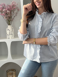 Adoptez cette chemise bleue et écrue femme, élégante et féminine. Dotée de manches longues, d’un col rond et de boutons sur toute la longueur, elle se distingue par ses volants au col et le long de la fermeture. Ses rayures verticales bleues et écrues apportent une touche raffinée et allongent la silhouette.