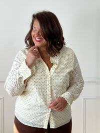 Chemise beige Sofia grande taille portée de face sur une jupe marron, montrant sa coupe ample et son bas arrondi.