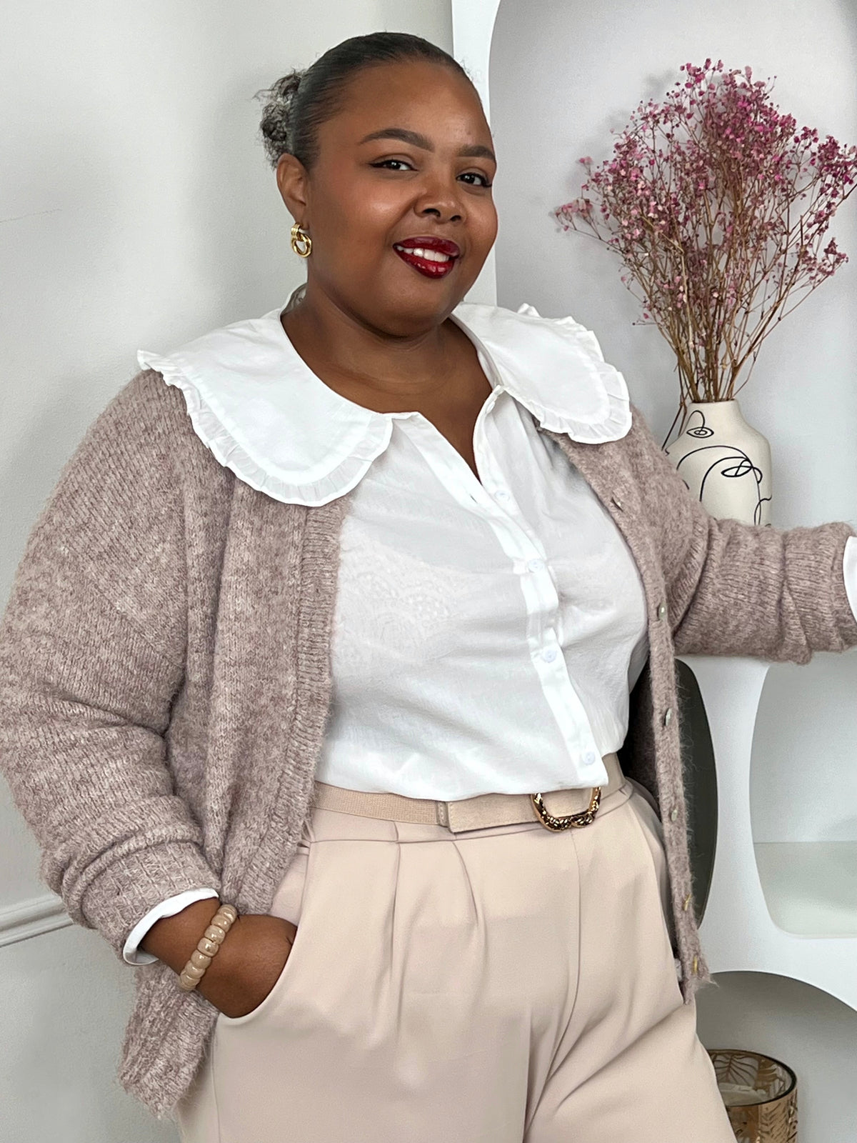 Chemise écrue grande taille femme avec col claudine brodé, portée sous un gilet beige.