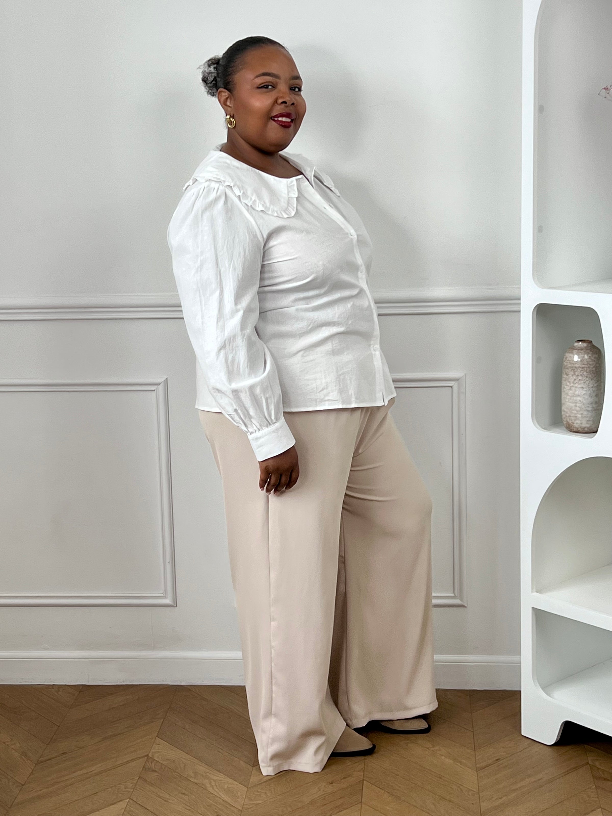 Chemise écrue femme avec manches longues, boutonnage sur le devant et volants au col.