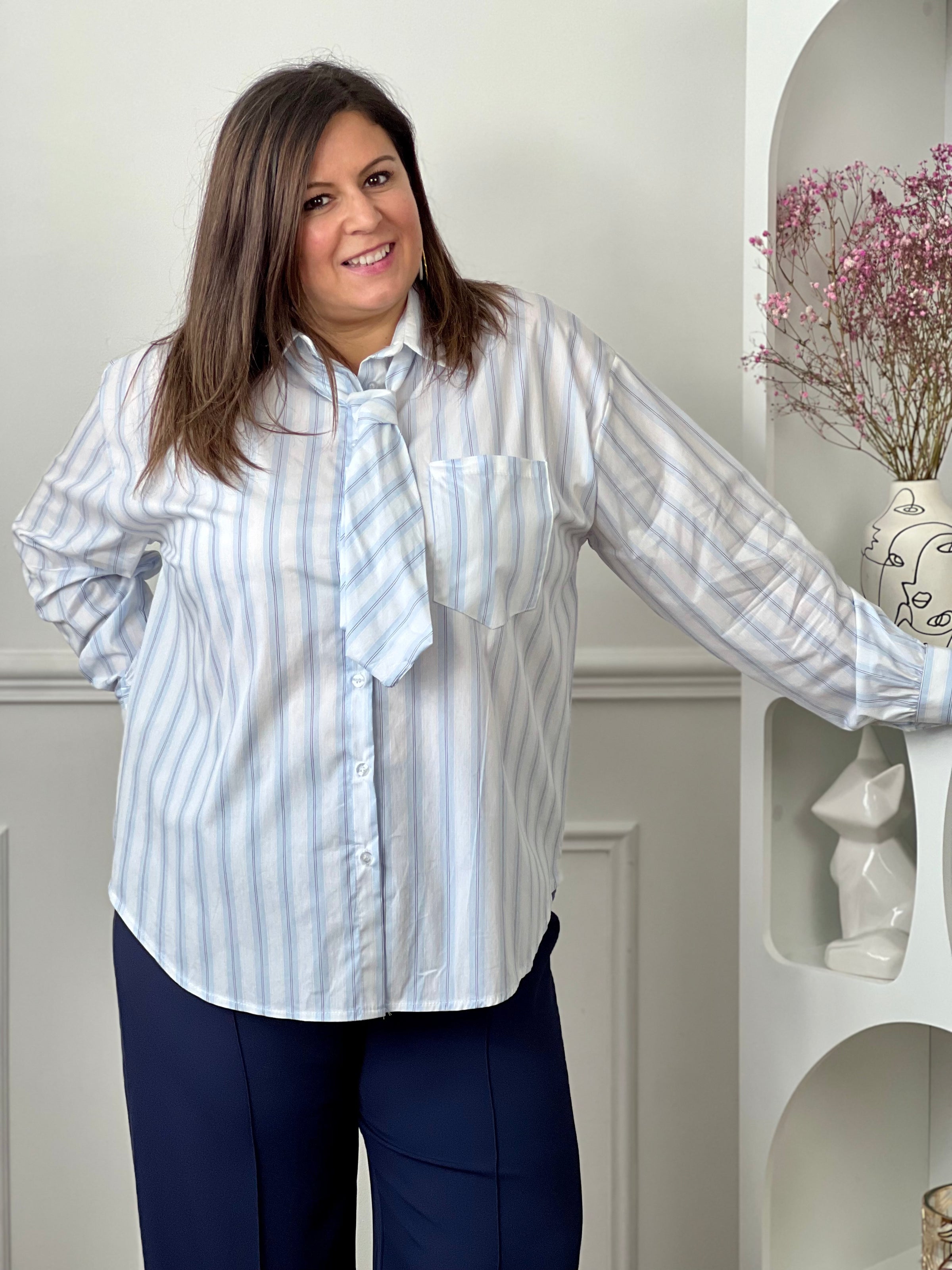 Chemise grande taille en coton à rayures verticales, parfaite pour une allure élégante et confortable. Dotée de manches longues, d’un col chemise avec lien à nouer et de boutons sur toute la longueur ainsi qu’aux poignets, elle apporte une touche chic et féminine. Sa coupe fluide met en valeur toutes les silhouettes.