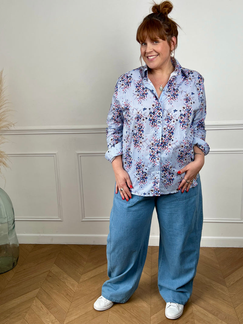 Laissez-vous séduire par cette chemise fleurie grande taille femme, élégante et pleine de fraîcheur. Dotée de manches longues avec boutons aux poignets et d’une fermeture boutonnée sur toute la longueur, elle présente un col chemise classique. Ses rayures verticales bleues et écrues sont sublimées par de motifs fleurs colorées, pour un look à la fois féminin et lumineux.