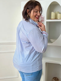 Chemise en coton grande taille femme, parfaite pour un look à la fois élégant et original. Dotée de manches longues, d’un col chemise et de boutons rouges sur toute la longueur ainsi qu’aux poignets, elle se distingue par ses rayures verticales bleues et écrues. Ses détails brodés, avec des cœurs au col et l’inscription "La vie est belle" aux poignets, apportent une touche unique et tendance