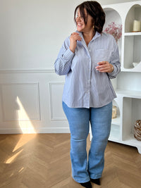 Chemise grande taille bleue et blanche à rayures, élégante et facile à porter au quotidien. Dotée de manches longues, de boutons sur toute la longueur et d’un col montant à volants, elle apporte une touche féminine et raffinée. Parfaite pour un look chic et moderne en toute simplicité.