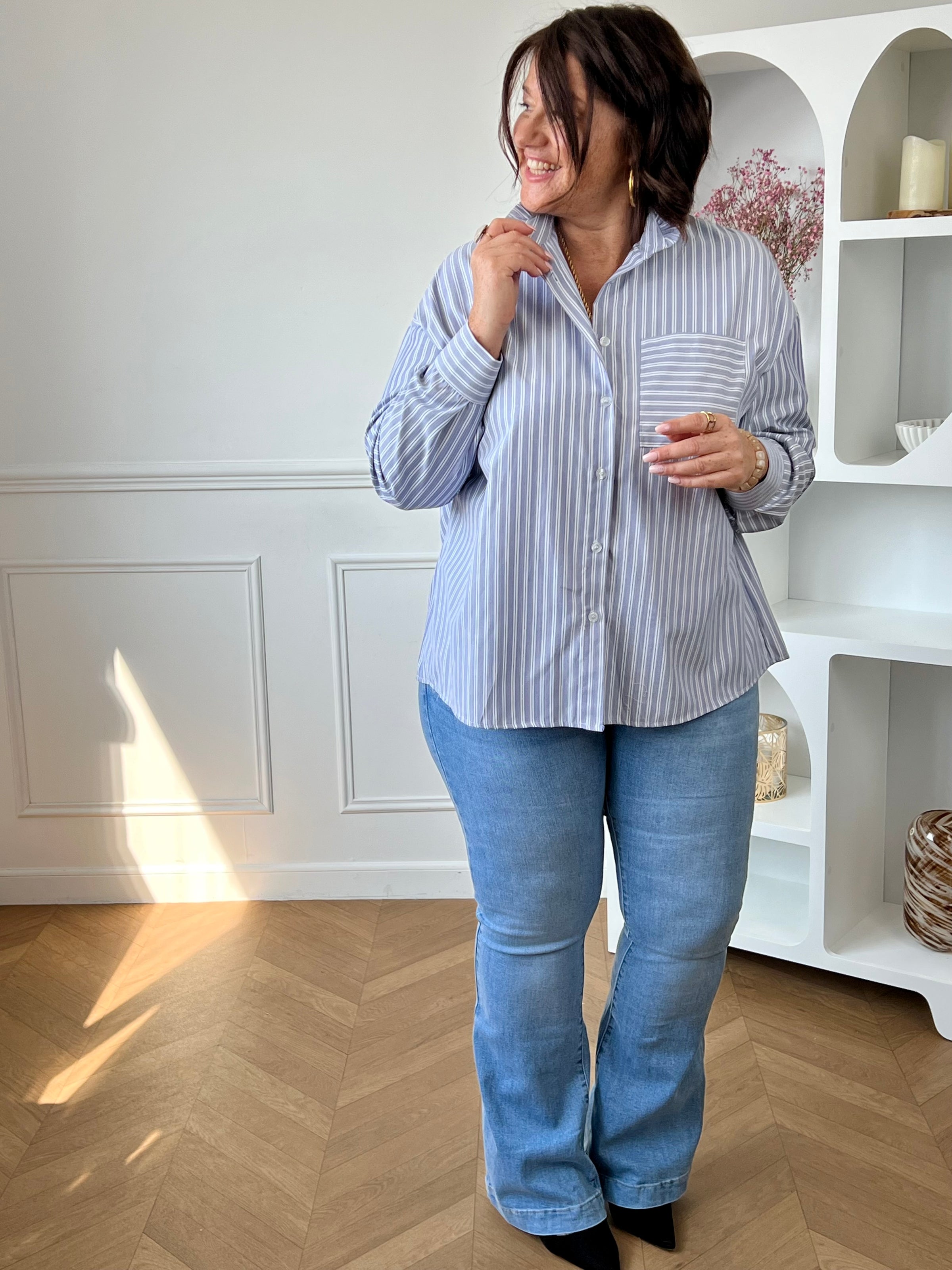 Chemise grande taille bleue et blanche à rayures, élégante et facile à porter au quotidien. Dotée de manches longues, de boutons sur toute la longueur et d’un col montant à volants, elle apporte une touche féminine et raffinée. Parfaite pour un look chic et moderne en toute simplicité.