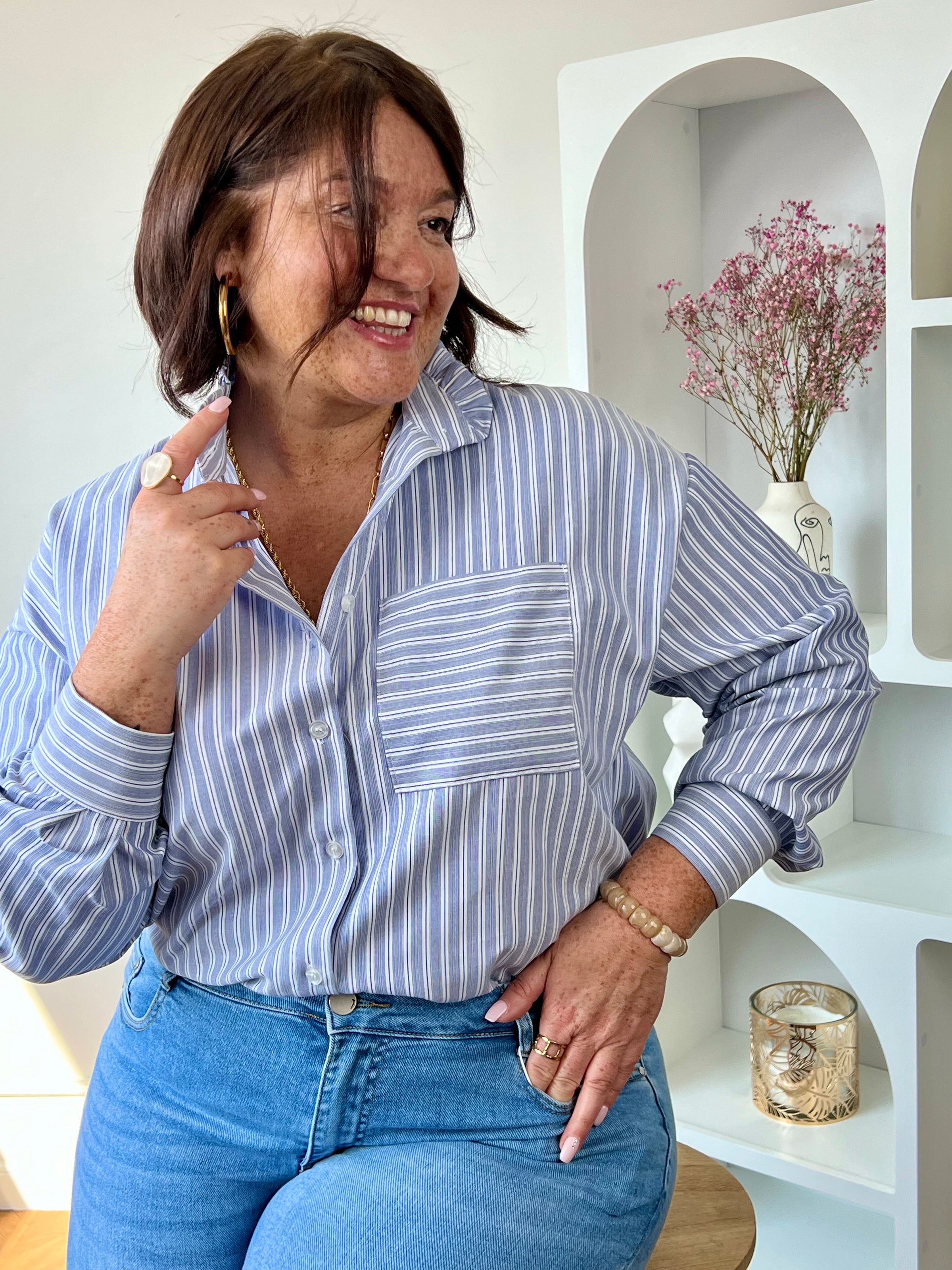 Chemise grande taille bleue et blanche à rayures, élégante et facile à porter au quotidien. Dotée de manches longues, de boutons sur toute la longueur et d’un col montant à volants, elle apporte une touche féminine et raffinée. Parfaite pour un look chic et moderne en toute simplicité.