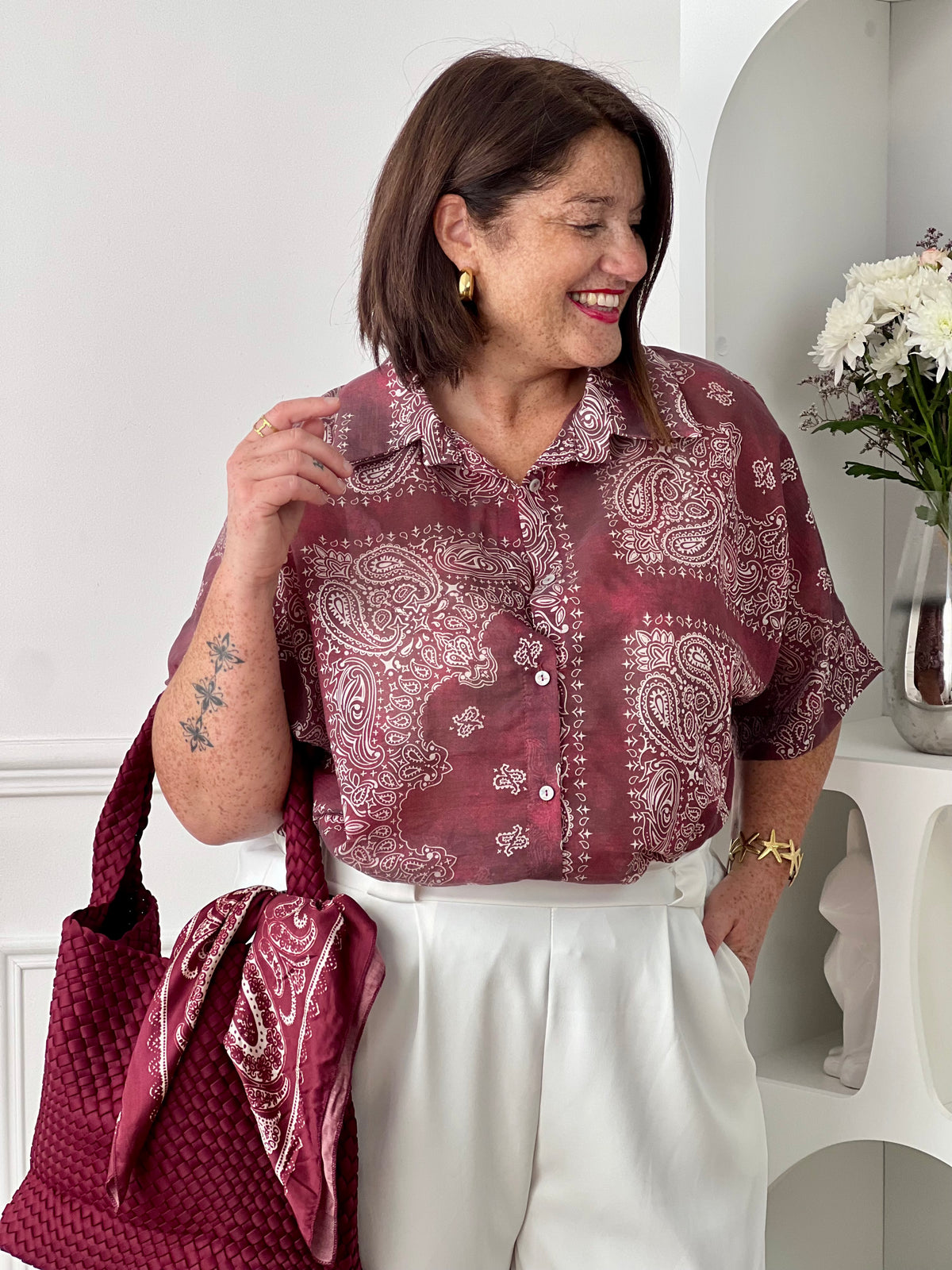 Adoptez un style chic et léger avec cette chemise grande taille femme aux motifs écrus élégants. Ses manches courtes, son col chemise classique et ses boutons sur toute la longueur en font une pièce facile à porter au quotidien. Légèrement transparente, elle apporte une touche féminine et aérienne, tandis que son association de bordeaux et d’écru offre un look tendance et raffiné.