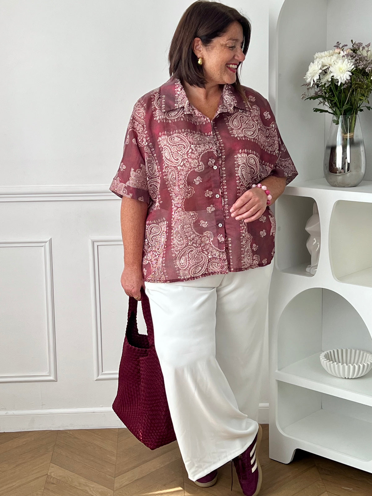 Adoptez un style chic et léger avec cette chemise grande taille femme aux motifs écrus élégants. Ses manches courtes, son col chemise classique et ses boutons sur toute la longueur en font une pièce facile à porter au quotidien. Légèrement transparente, elle apporte une touche féminine et aérienne, tandis que son association de bordeaux et d’écru offre un look tendance et raffiné.