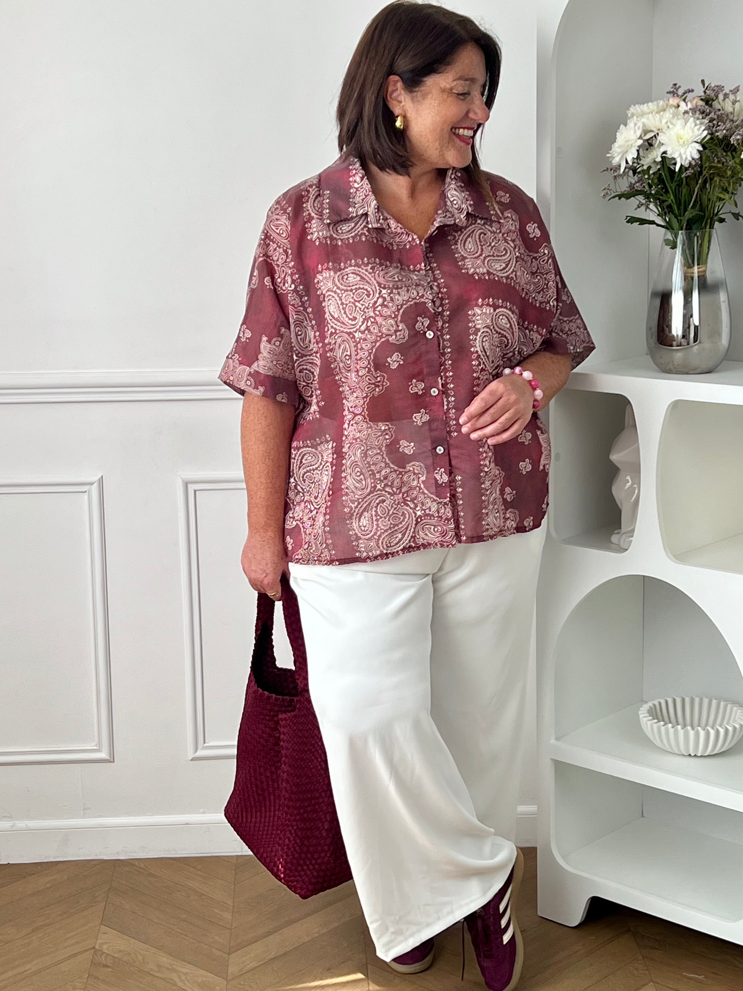 Adoptez un style chic et léger avec cette chemise grande taille femme aux motifs écrus élégants. Ses manches courtes, son col chemise classique et ses boutons sur toute la longueur en font une pièce facile à porter au quotidien. Légèrement transparente, elle apporte une touche féminine et aérienne, tandis que son association de bordeaux et d’écru offre un look tendance et raffiné.