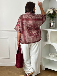Adoptez un style chic et léger avec cette chemise grande taille femme aux motifs écrus élégants. Ses manches courtes, son col chemise classique et ses boutons sur toute la longueur en font une pièce facile à porter au quotidien. Légèrement transparente, elle apporte une touche féminine et aérienne, tandis que son association de bordeaux et d’écru offre un look tendance et raffiné.