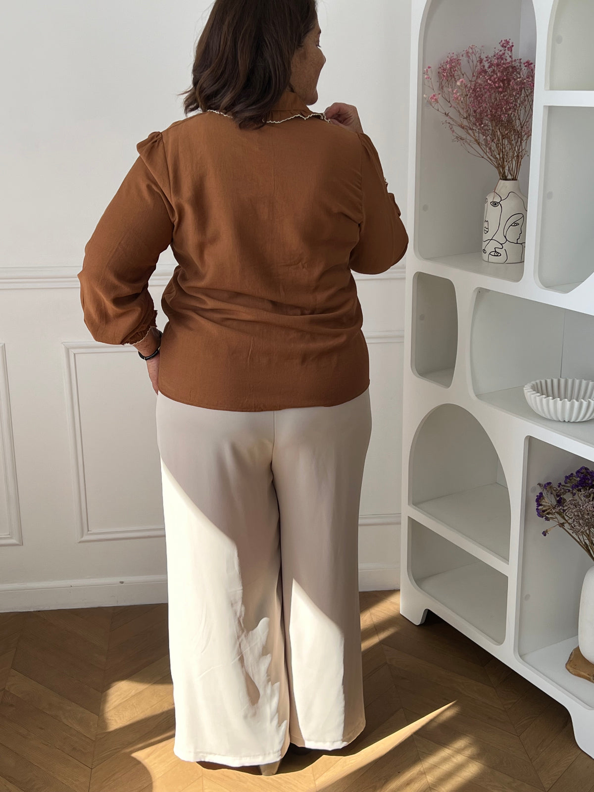Chemise camel Salil portée de dos avec un pantalon beige, montrant le dos uni et les manches longues.