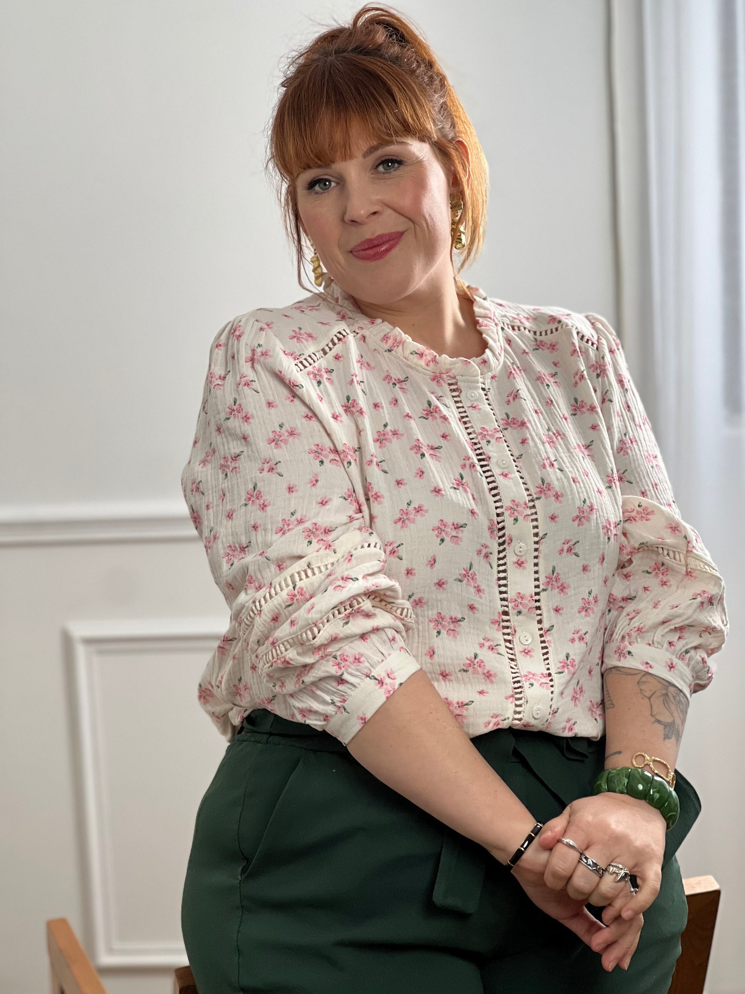 Découvrez la chemise Anelia, une pièce incontournable pour un style bohème et confortable. Confectionnée en 100% coton, cette chemise grande taille allie élégance et légèreté avec ses détails ajourés délicats sur le devant et aux manches. Le col montant et les manches longues offrent une couverture raffinée. Les motifs floraux roses et verts sur fond beige apportent une touche naturelle et féminine à votre garde-robe.