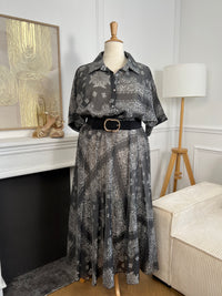 Adoptez un style chic et léger avec cette chemise grande taille femme aux motifs écrus élégants. Ses manches courtes, son col chemise classique et ses boutons sur toute la longueur en font une pièce facile à porter au quotidien. Légèrement transparente, elle apporte une touche féminine et aérienne, tandis que son association de gris et d’écru offre un look tendance et raffiné.