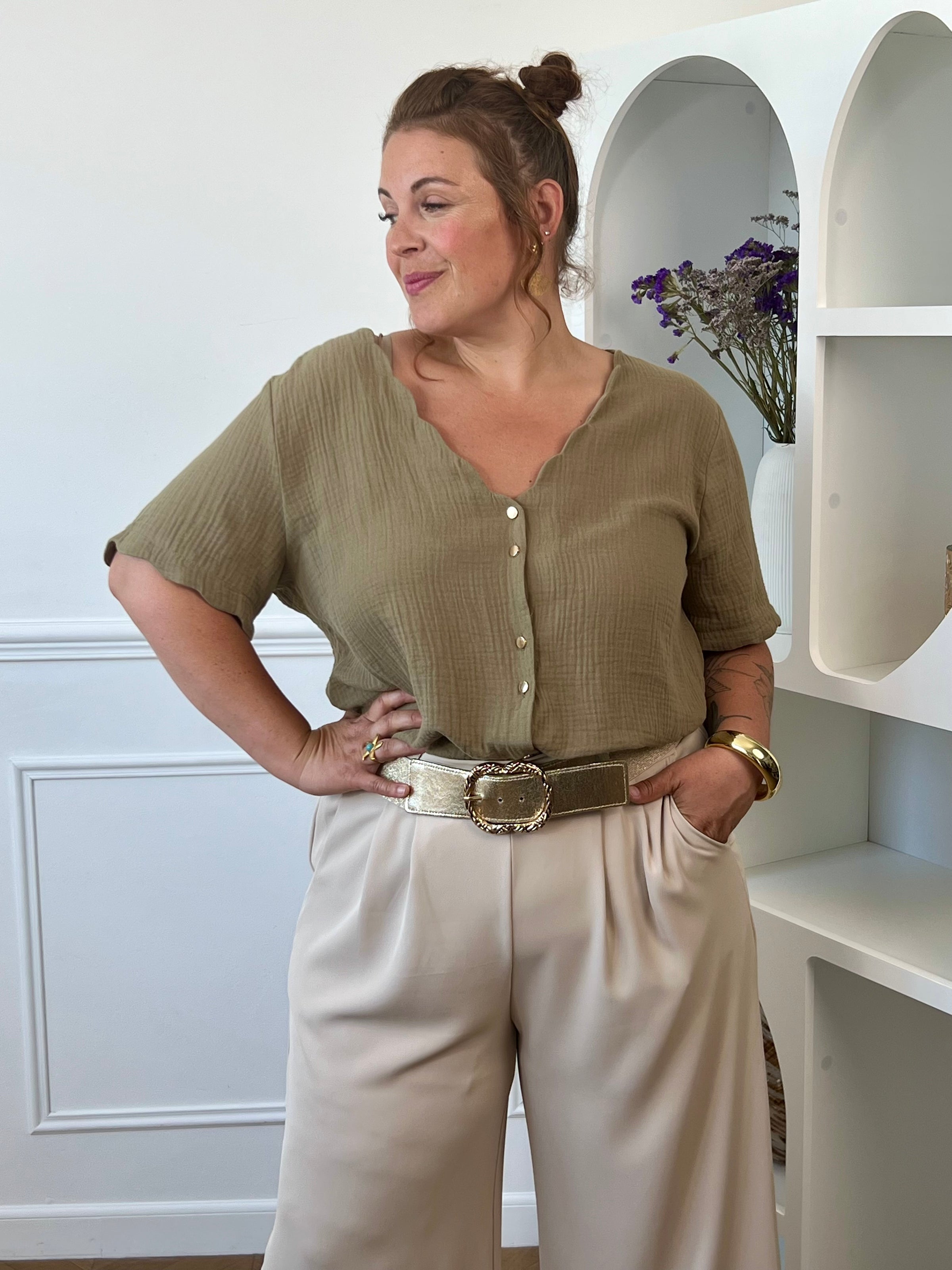 Découvrez notre ravissante chemise kaki en gaze de coton Kira ! Avec son col V festonné et ses boutons dorés, elle apporte une touche d'élégance à votre tenue. Légère et confortable en 100% coton, elle vous séduira par sa couleur noir intemporelle.