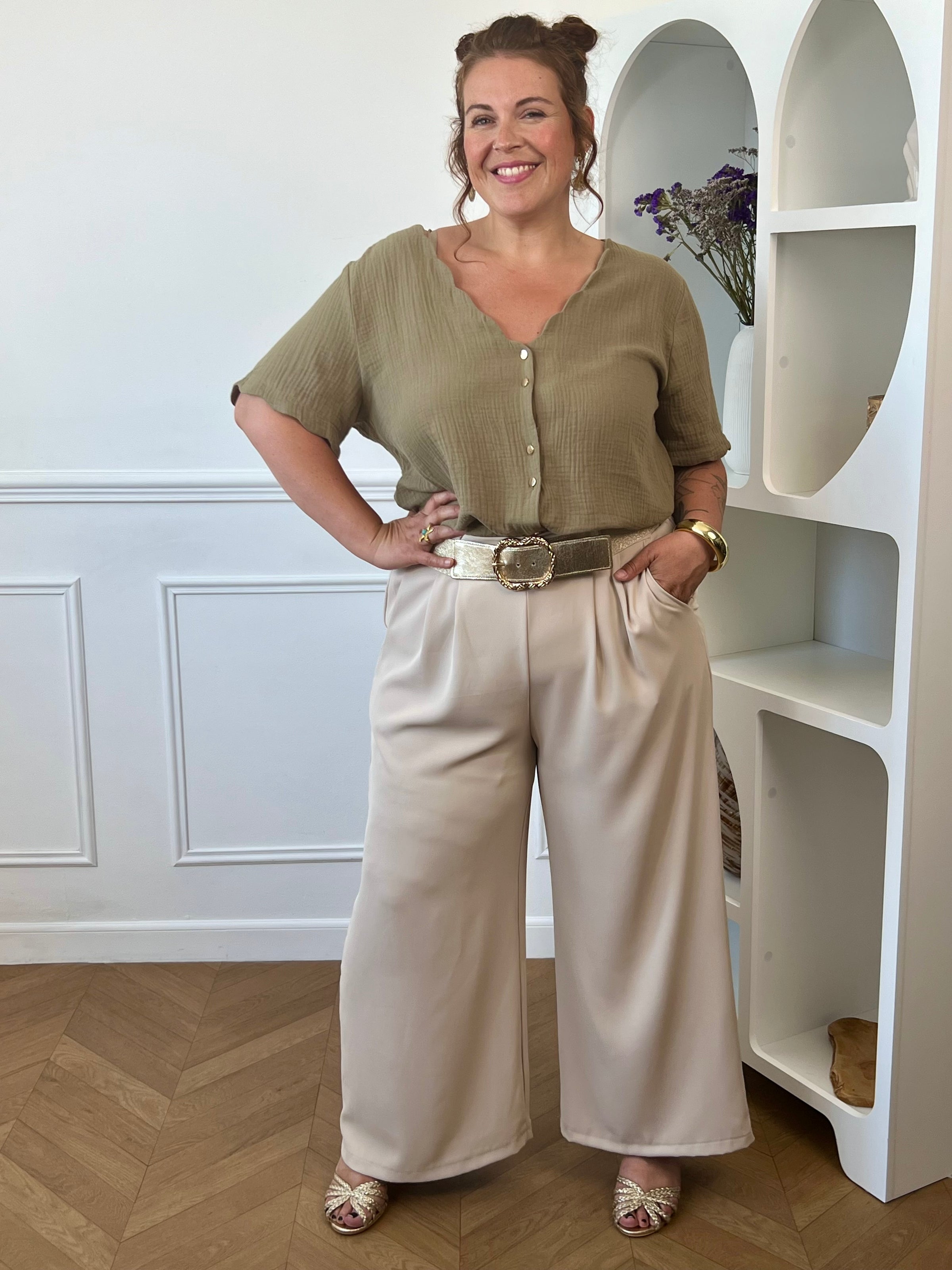 Découvrez notre ravissante chemise kaki en gaze de coton Kira ! Avec son col V festonné et ses boutons dorés, elle apporte une touche d'élégance à votre tenue. Légère et confortable en 100% coton, elle vous séduira par sa couleur noir intemporelle.