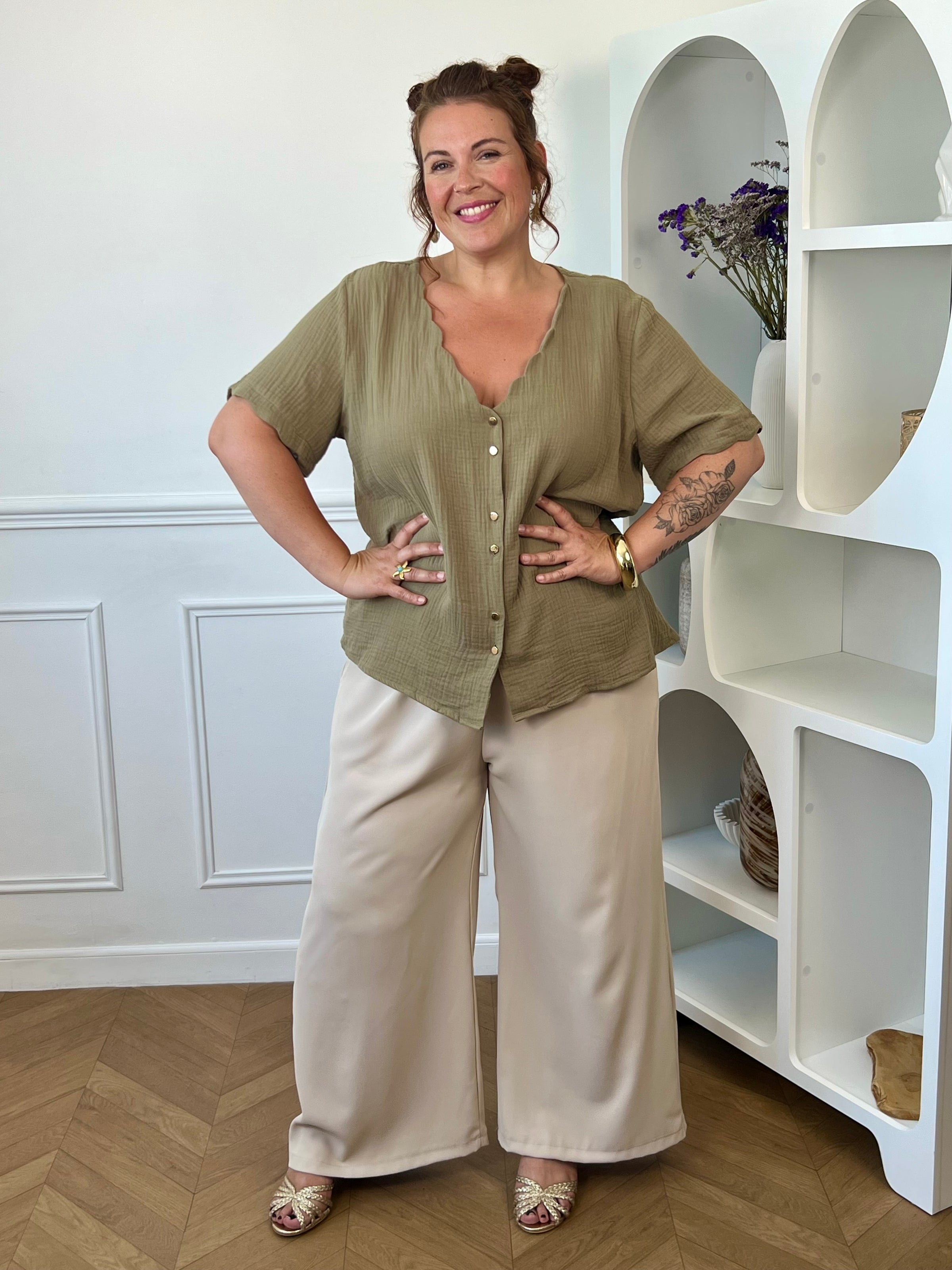 Découvrez notre ravissante chemise kaki en gaze de coton Kira ! Avec son col V festonné et ses boutons dorés, elle apporte une touche d'élégance à votre tenue. Légère et confortable en 100% coton, elle vous séduira par sa couleur noir intemporelle.