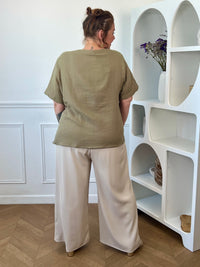 Découvrez notre ravissante chemise kaki en gaze de coton Kira ! Avec son col V festonné et ses boutons dorés, elle apporte une touche d'élégance à votre tenue. Légère et confortable en 100% coton, elle vous séduira par sa couleur noir intemporelle.