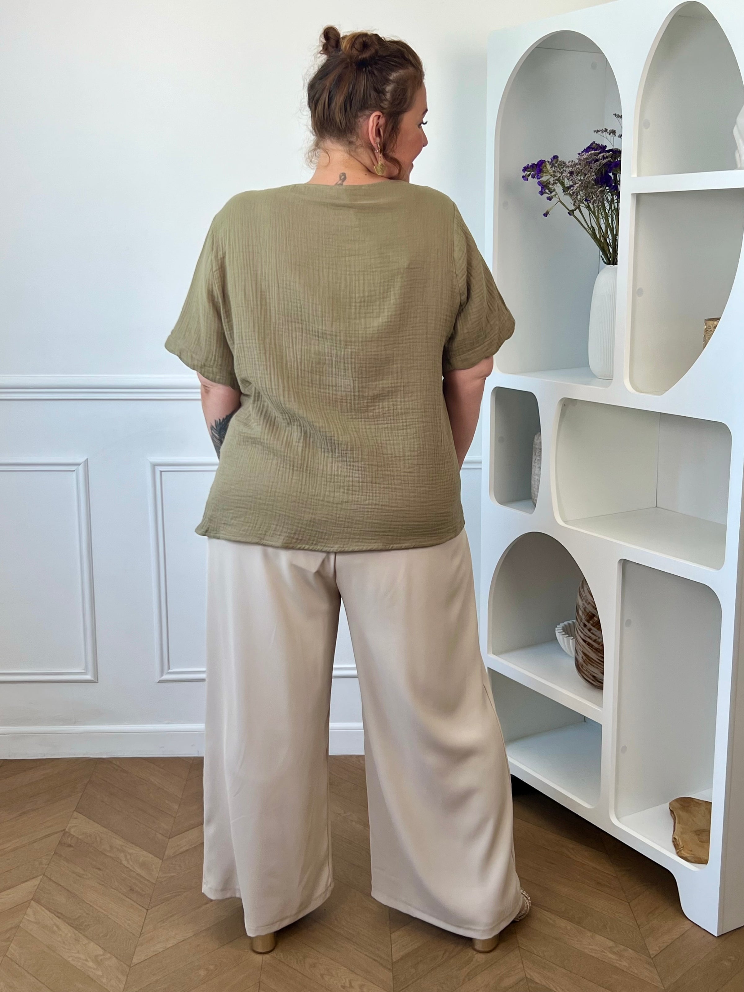Découvrez notre ravissante chemise kaki en gaze de coton Kira ! Avec son col V festonné et ses boutons dorés, elle apporte une touche d'élégance à votre tenue. Légère et confortable en 100% coton, elle vous séduira par sa couleur noir intemporelle.