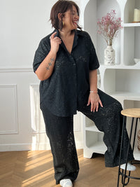 Chemise noire à sequins grande taille, idéale pour un look élégant et lumineux. Sa coupe manches courtes avec boutons sur la longueur offre confort et style, tandis que son effet ajouré apporte une touche moderne. Parfaite pour sublimer vos tenues de soirée ou du quotidien.