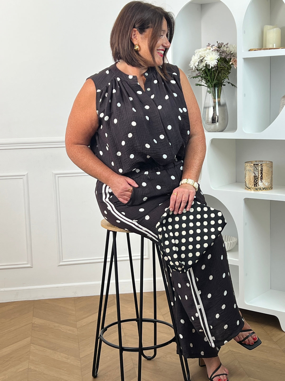 Craquez pour cette chemise à motifs grande taille femme, idéale pour un look à la fois chic et décontracté. Sans manches et dotée d’un col rond, elle séduit par ses élégants motifs pois noir et écru qui apportent une touche intemporelle à votre tenue. Les boutons sur toute la longueur soulignent son style raffiné, tandis que sa matière légèrement transparente lui confère légèreté et féminité. Une pièce tendance et confortable, parfaite pour la saison.
