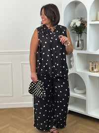 Craquez pour cette chemise à motifs grande taille femme, idéale pour un look à la fois chic et décontracté. Sans manches et dotée d’un col rond, elle séduit par ses élégants motifs pois noir et écru qui apportent une touche intemporelle à votre tenue. Les boutons sur toute la longueur soulignent son style raffiné, tandis que sa matière légèrement transparente lui confère légèreté et féminité. Une pièce tendance et confortable, parfaite pour la saison.