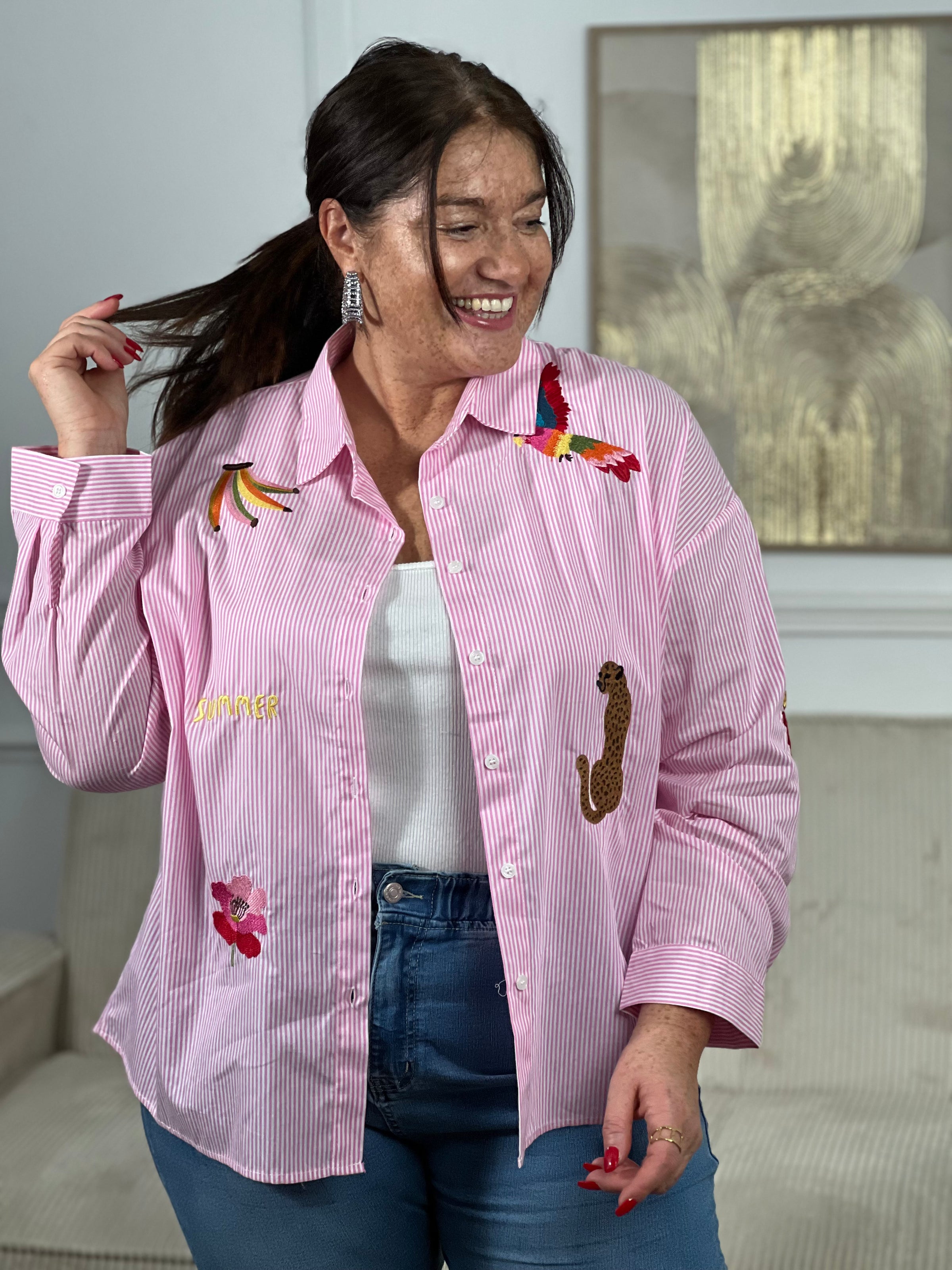 Découvrez Adia, notre chemise en coton grande taille pensée pour vous. Avec ses manches longues et son col chemise classique, elle allie élégance et confort. Les rayures verticales bleues et écrues créent une base intemporelle, sublimée par des motifs brodés colorés qui ajoutent du caractère.