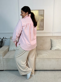 La chemise Naelis allie style et confort en grande taille. Ses rayures verticales rose et écru affinent la silhouette, tandis que le col montant à volants apporte une touche élégante. Manches longues avec boutons aux poignets, coupe légèrement plus long à l'arrière pour un port optimal.