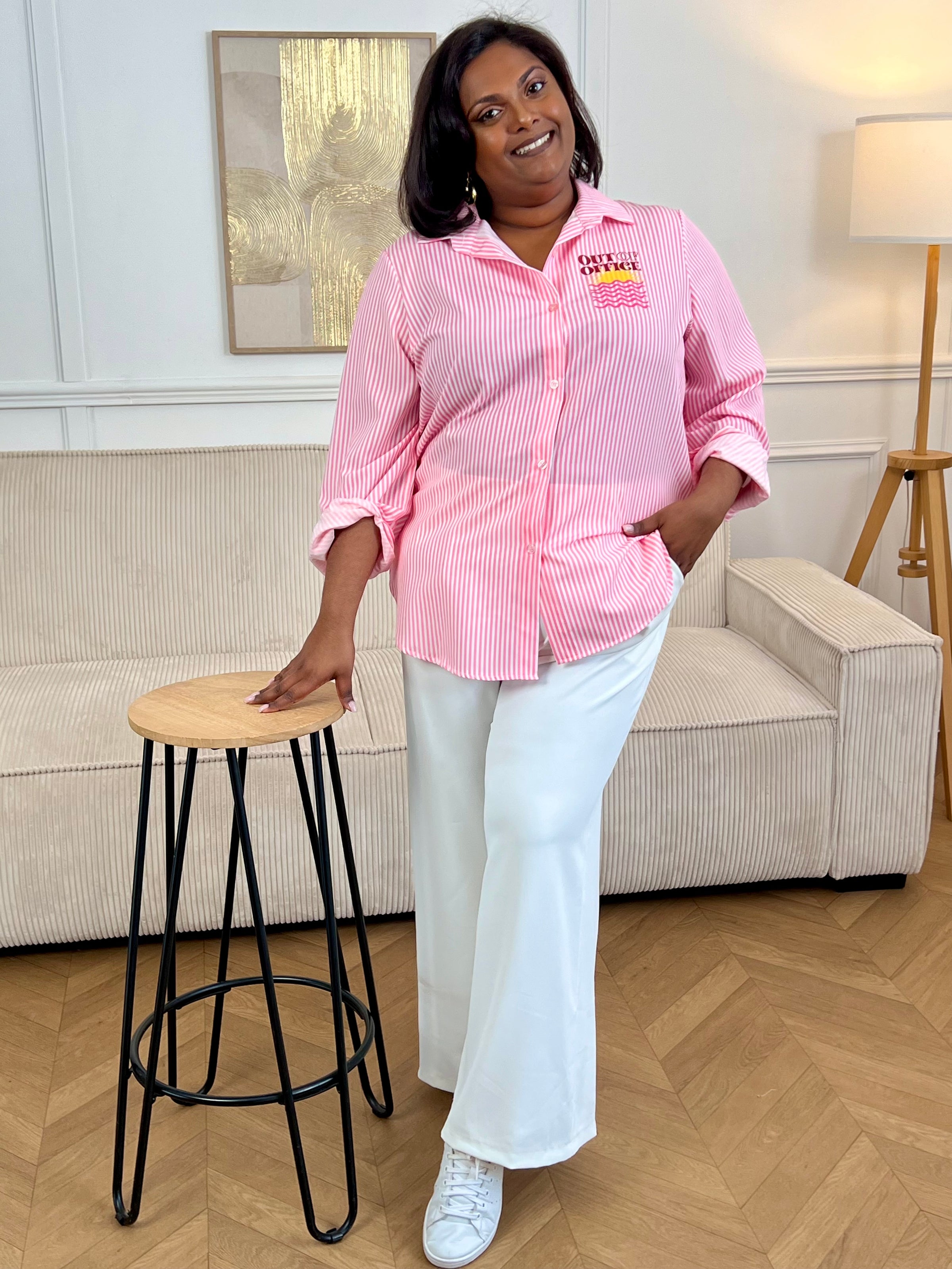 Laissez-vous séduire par cette chemise grande taille femme, légère et fluide, idéale pour la saison. Dotée d’un col chemise classique et de manches longues, elle se ferme par des boutons sur toute la longueur et aux poignets. Ses rayures verticales roses et écrues allongent la silhouette, tandis que les motifs soleil avec l’inscription “Out of office” apportent une touche originale et estivale à votre look.