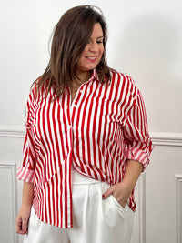 Découvrez Kaely, la chemise parfaite pour affirmer votre style avec assurance. Ses rayures verticales rouge et écru créent une ligne flatteuse qui met en valeur votre silhouette. Réalisée en coton de qualité, elle garantit confort et durabilité tout au long de la journée. Le col chemise intemporel, les manches longues et la rangée de boutons complète offrent une allure soignée et professionnelle.
