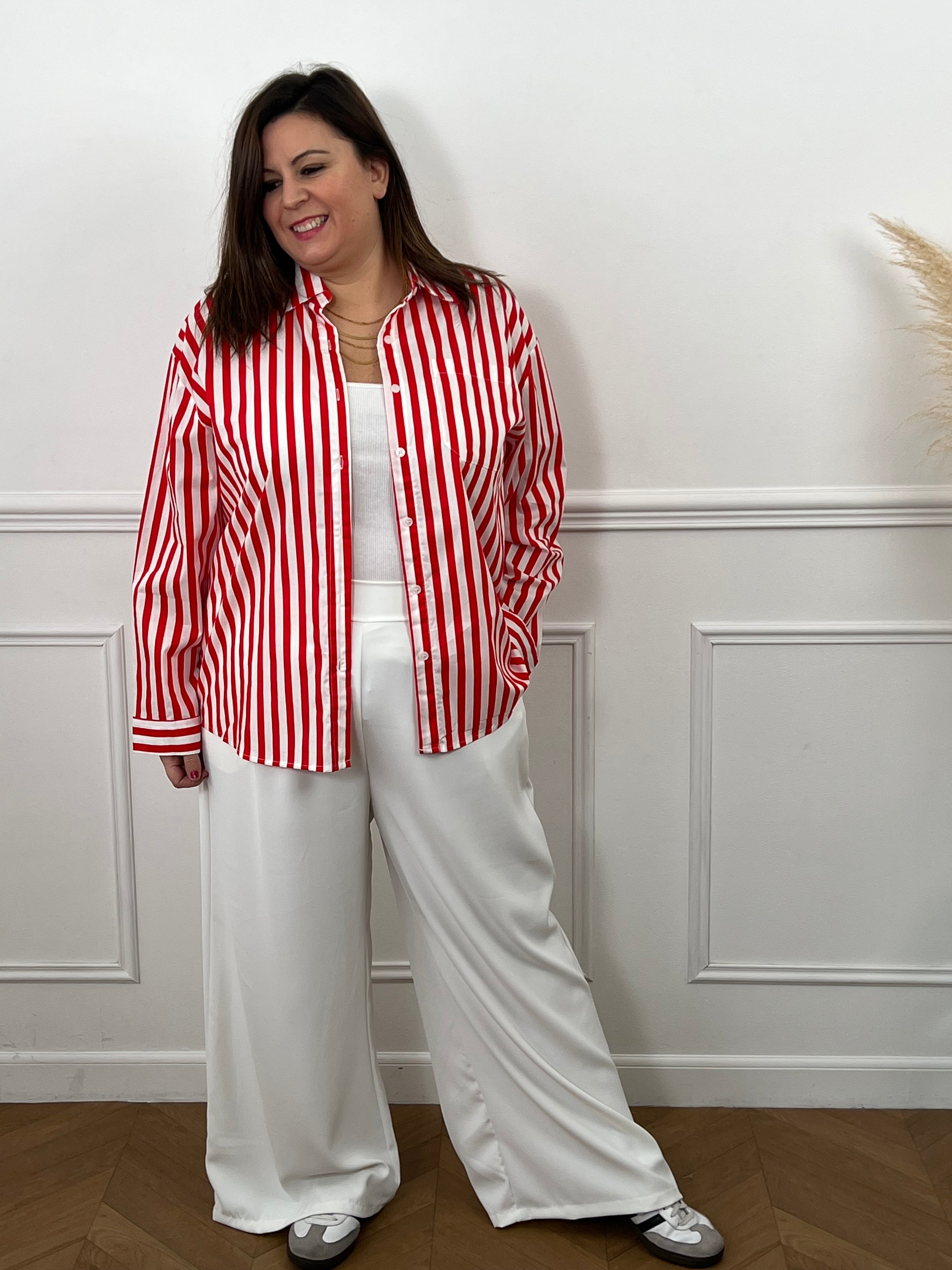 Découvrez Kaely, la chemise parfaite pour affirmer votre style avec assurance. Ses rayures verticales rouge et écru créent une ligne flatteuse qui met en valeur votre silhouette. Réalisée en coton de qualité, elle garantit confort et durabilité tout au long de la journée. Le col chemise intemporel, les manches longues et la rangée de boutons complète offrent une allure soignée et professionnelle.