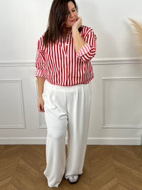Découvrez Kaely, la chemise parfaite pour affirmer votre style avec assurance. Ses rayures verticales rouge et écru créent une ligne flatteuse qui met en valeur votre silhouette. Réalisée en coton de qualité, elle garantit confort et durabilité tout au long de la journée. Le col chemise intemporel, les manches longues et la rangée de boutons complète offrent une allure soignée et professionnelle.