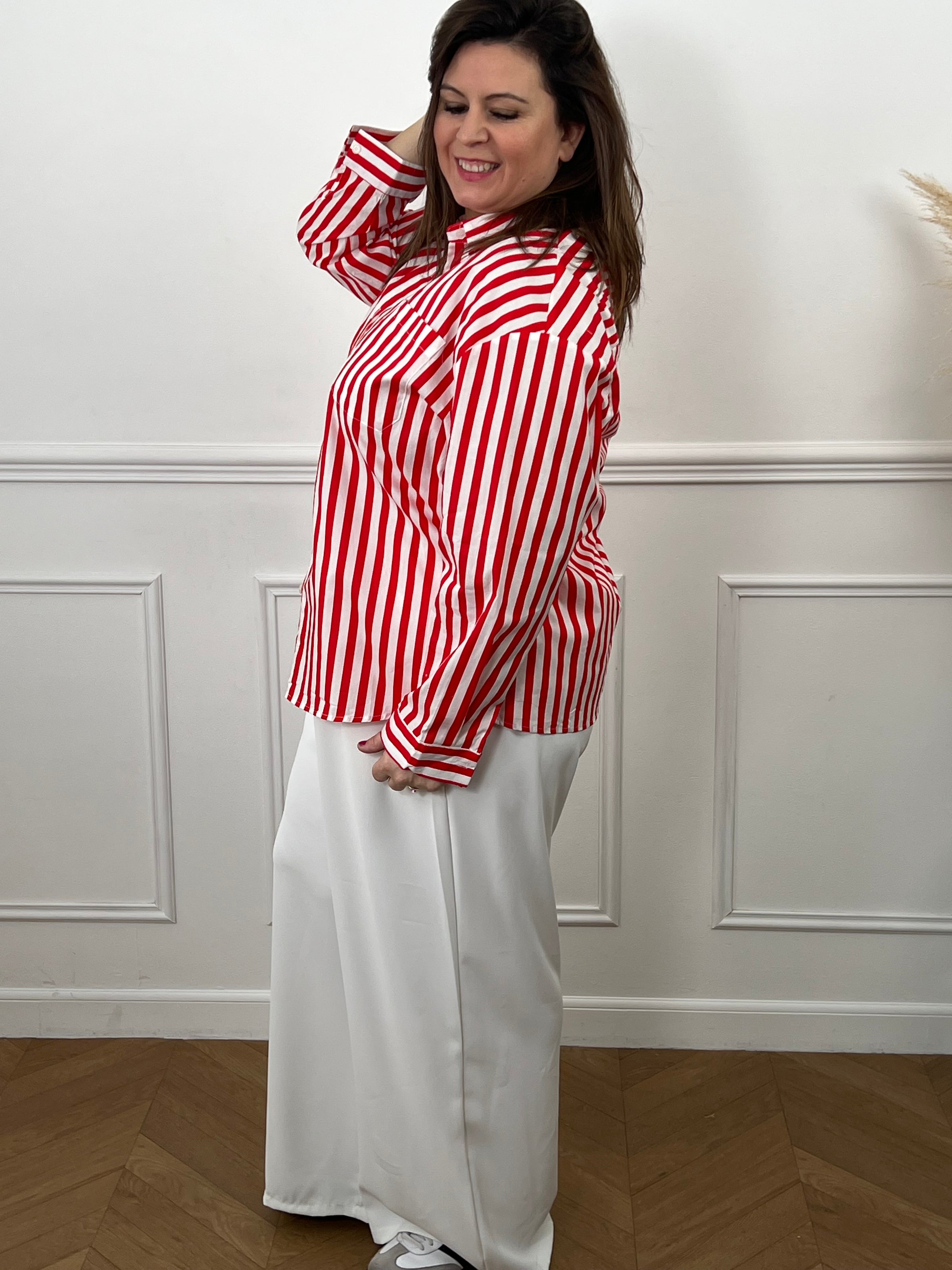 Découvrez Kaely, la chemise parfaite pour affirmer votre style avec assurance. Ses rayures verticales rouge et écru créent une ligne flatteuse qui met en valeur votre silhouette. Réalisée en coton de qualité, elle garantit confort et durabilité tout au long de la journée. Le col chemise intemporel, les manches longues et la rangée de boutons complète offrent une allure soignée et professionnelle.