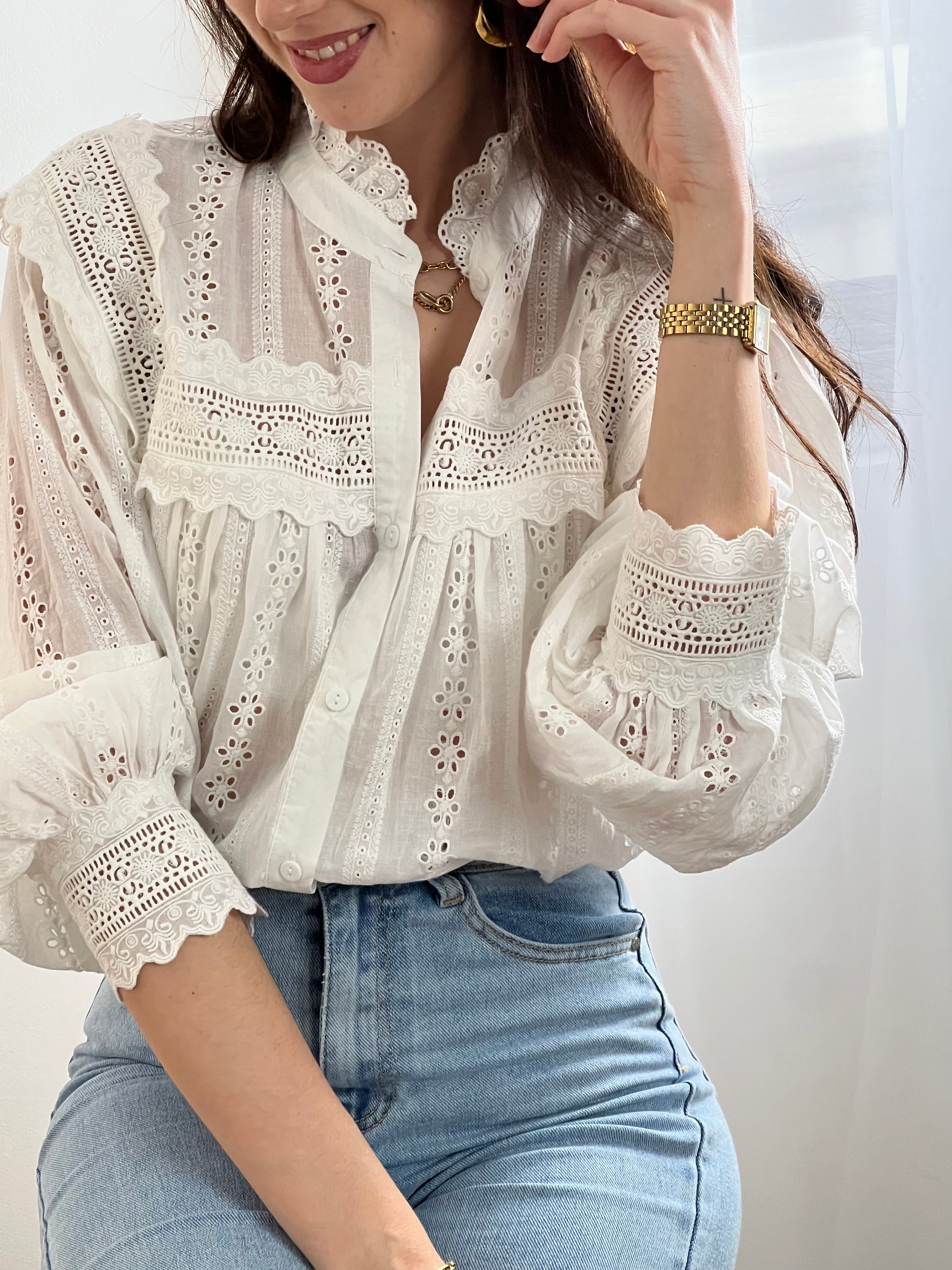 Chemise Angele en coton 100% pour les femmes. Manches bouffantes, col volant et broderie ajourée confèrent à cette pièce écrue une élégance intemporelle. Légèrement transparente, elle se porte avec aisance au quotidien comme en occasion.