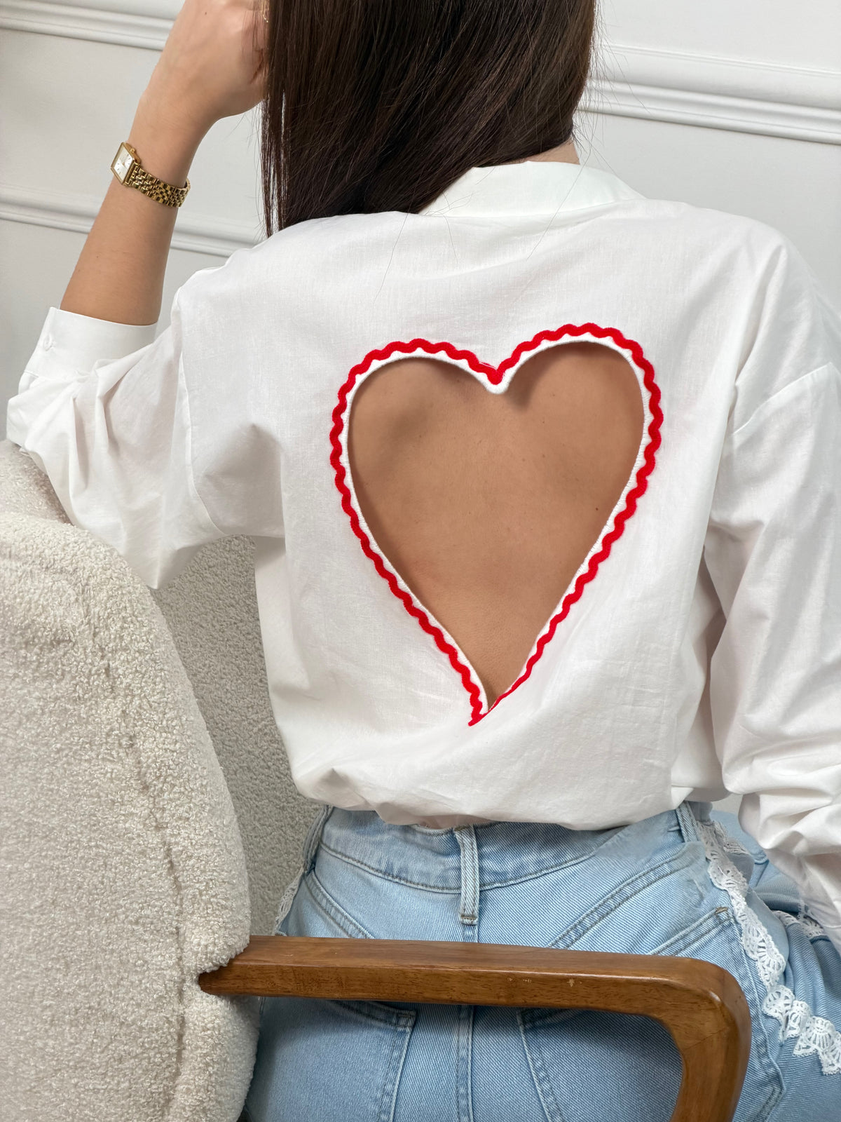 Chemise en coton aux détails romantiques et féminins. Manches longues avec boutons aux poignets, col chemise classique et fermeture boutonnée sur toute la longueur. La touche signature : une découpe en cœur rouge au dos qui ajoute une dimension poétique à cette pièce incontournable. Parfaite pour créer des looks à la fois élégants et originaux.